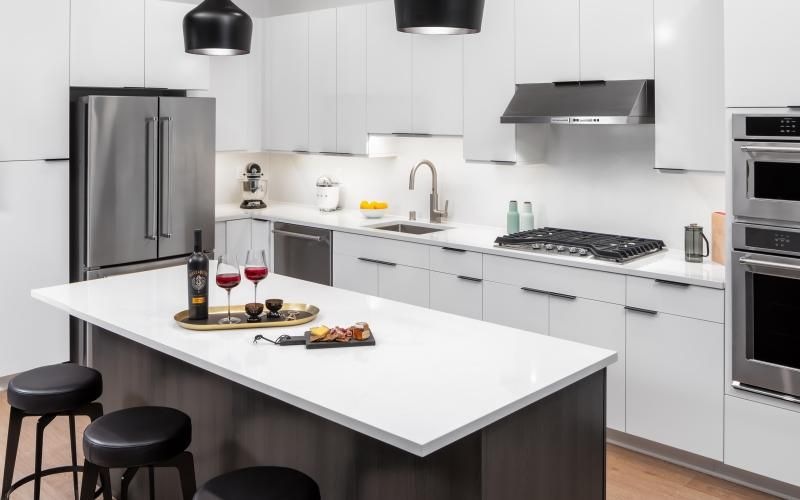 a kitchen with a white counter top and black stools